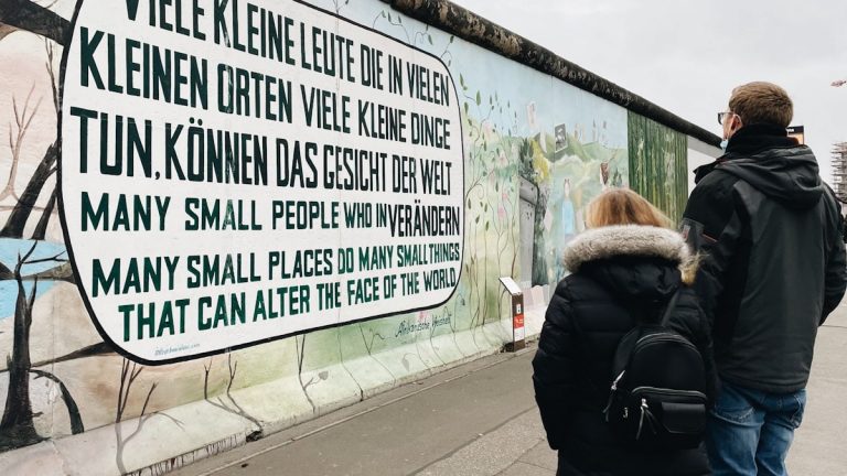 a man and a woman standing in front of a wall