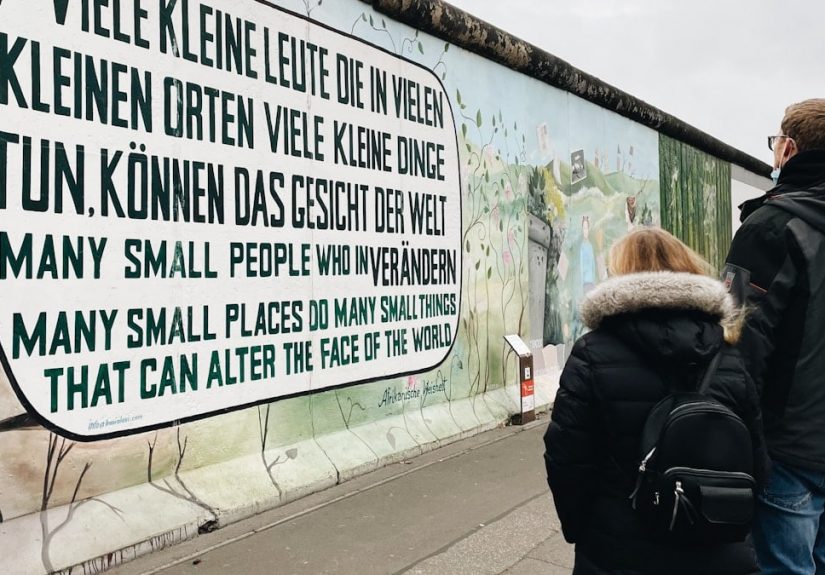 a man and a woman standing in front of a wall